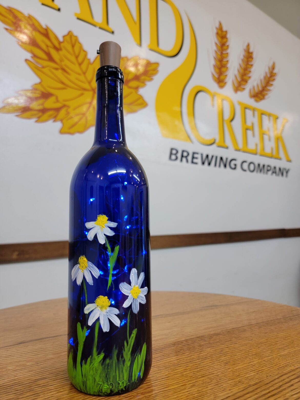 painting on wine bottles at the Sand Creek Brewing company